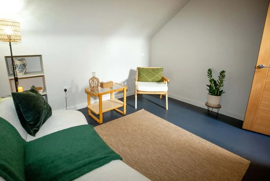 Rebecca's counselling room: a sofa, an armchair and a side table in soft daylight